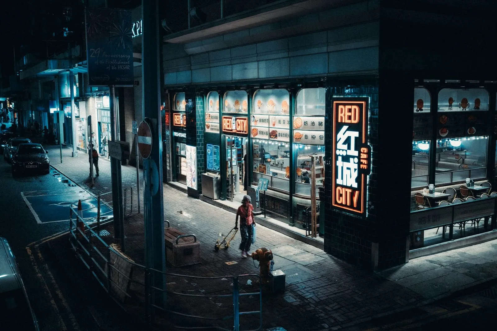 A cozy Asian-style café at dusk with city lights in the background.