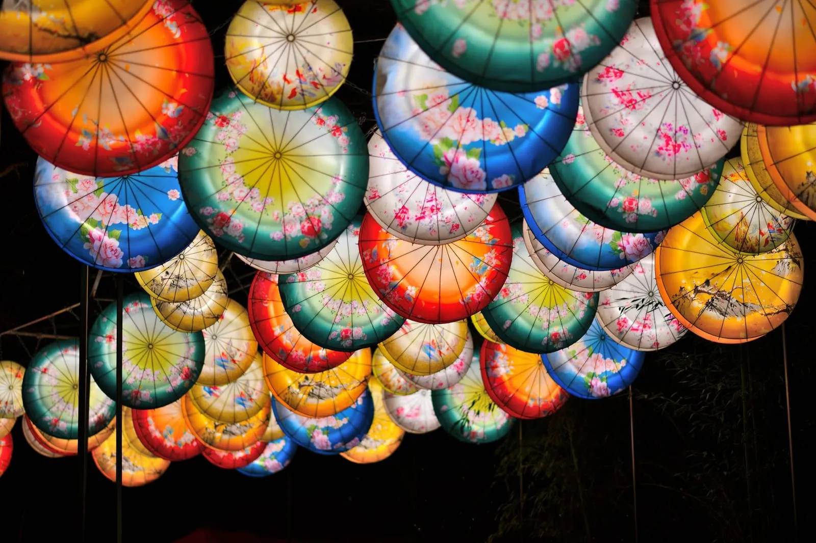 Glowing paper lanterns at an Asian festival at night.