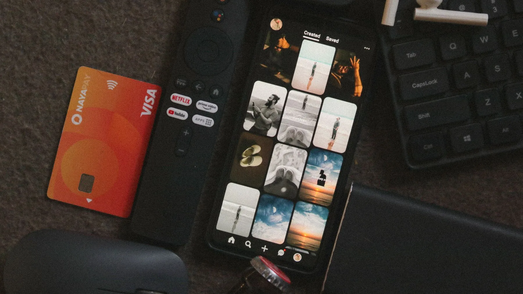 A smartphone beside a credit card and digital devices, representing app subscriptions.