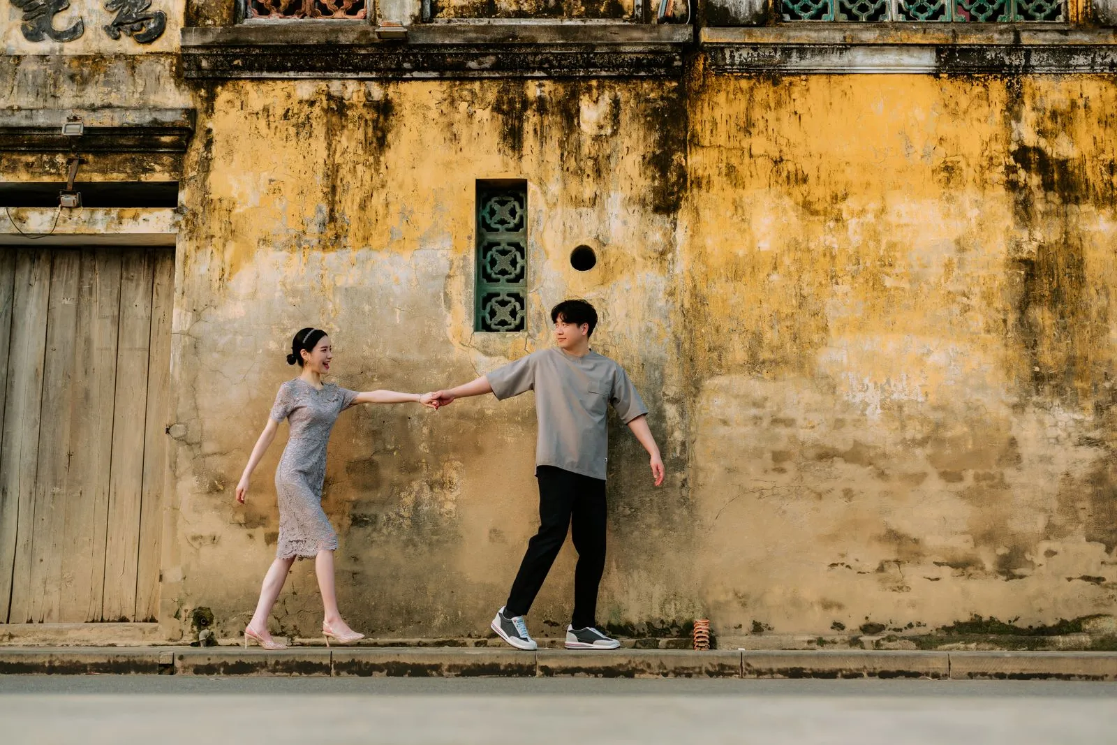 An Asian couple holding hands while walking outdoors