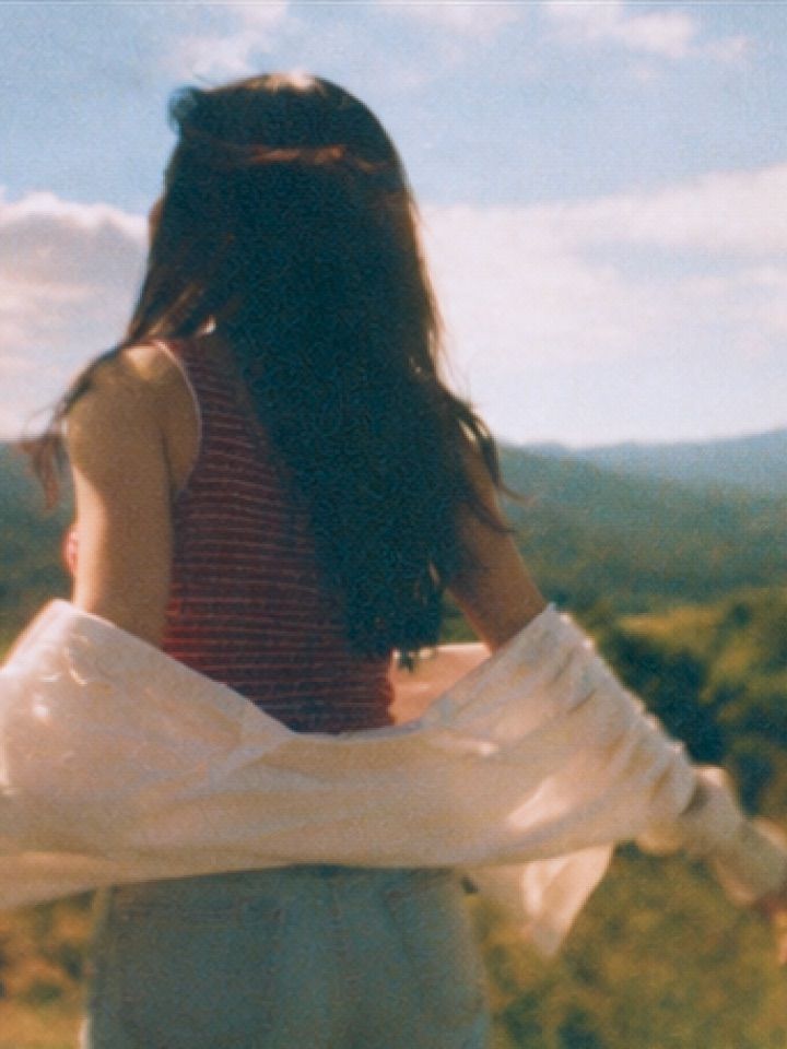 A traveler looking out over a range of distant mountains